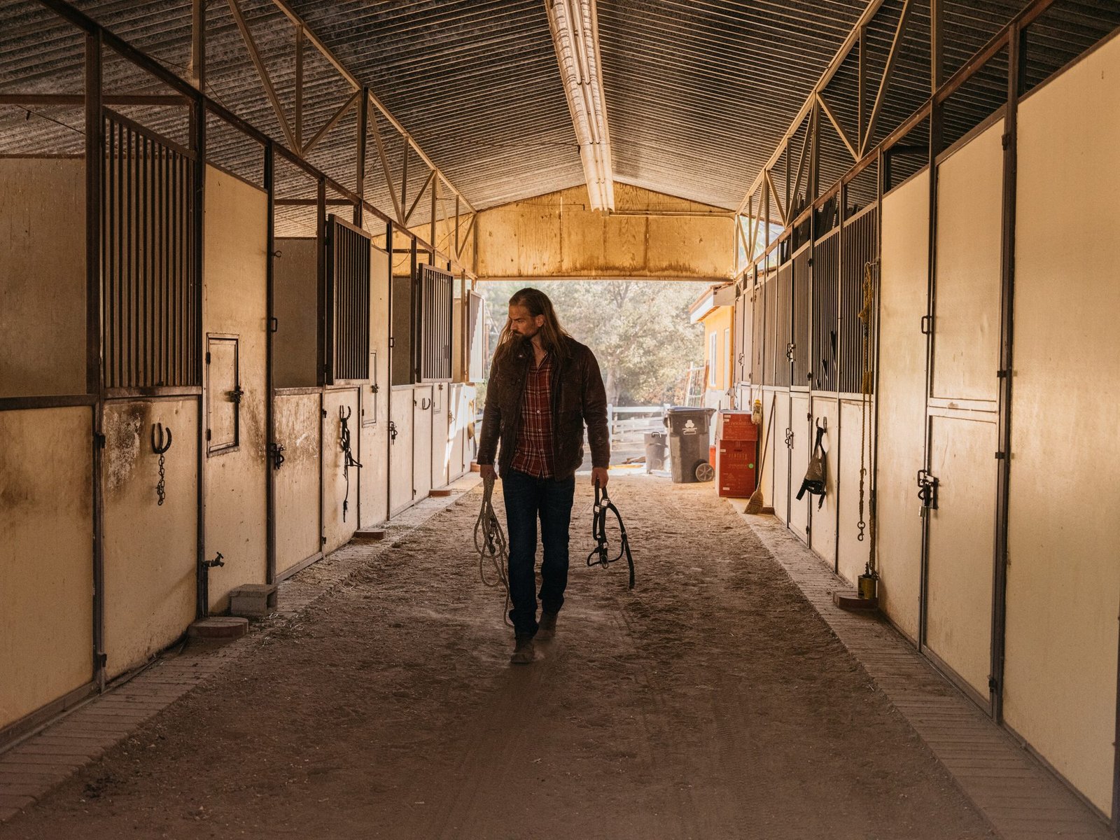 Covered barn aisle with stalls and warm light, Shadow Hills Ranch