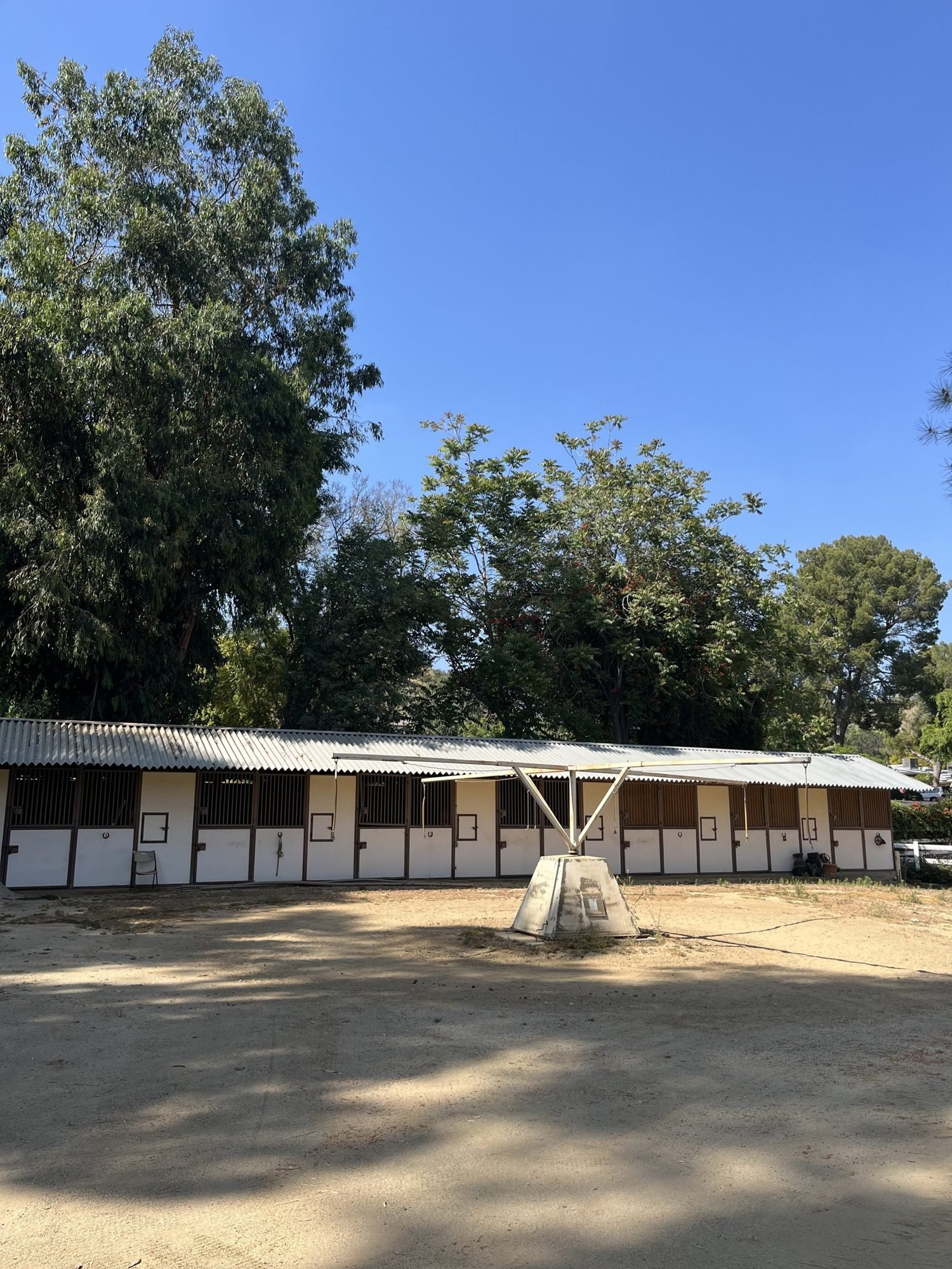 Stables and open arena under a clear sky, Shadow Hills Ranch